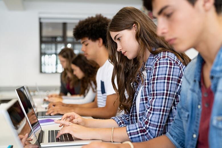 Students focused on laptops during a universal screening assessment